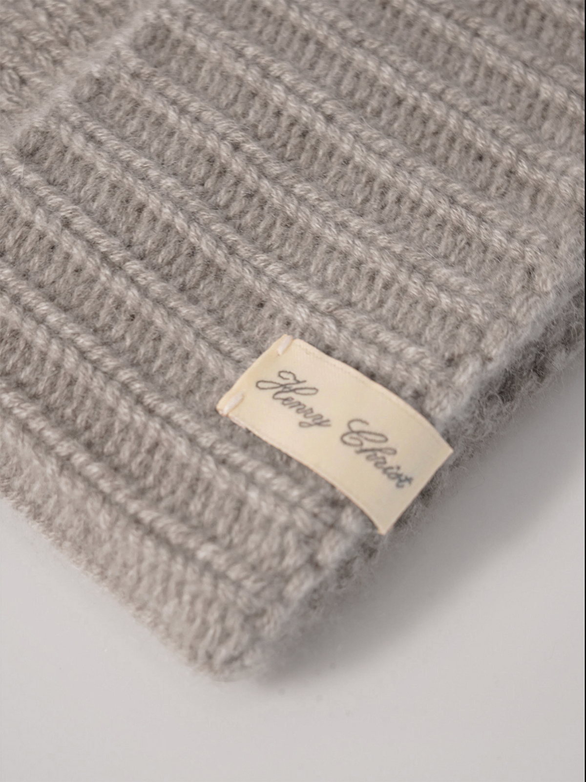 Graue Kaschmir-Mütze von Henry Christ – Detailansicht des gerippten Umschlags mit Label