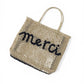Sandfarbene Bast-Tasche mit dunkelblauem Schriftzug "merci"