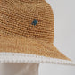 Sandfarbener Strohhut mit weißem Detail