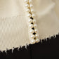 Cremefarbene Strickjacke mit Perlen
