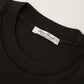 Dunkelbraunes T-Shirt aus feiner Rippe von Stefan Brandt – Detailansicht des Rundhalsausschnitts mit Label