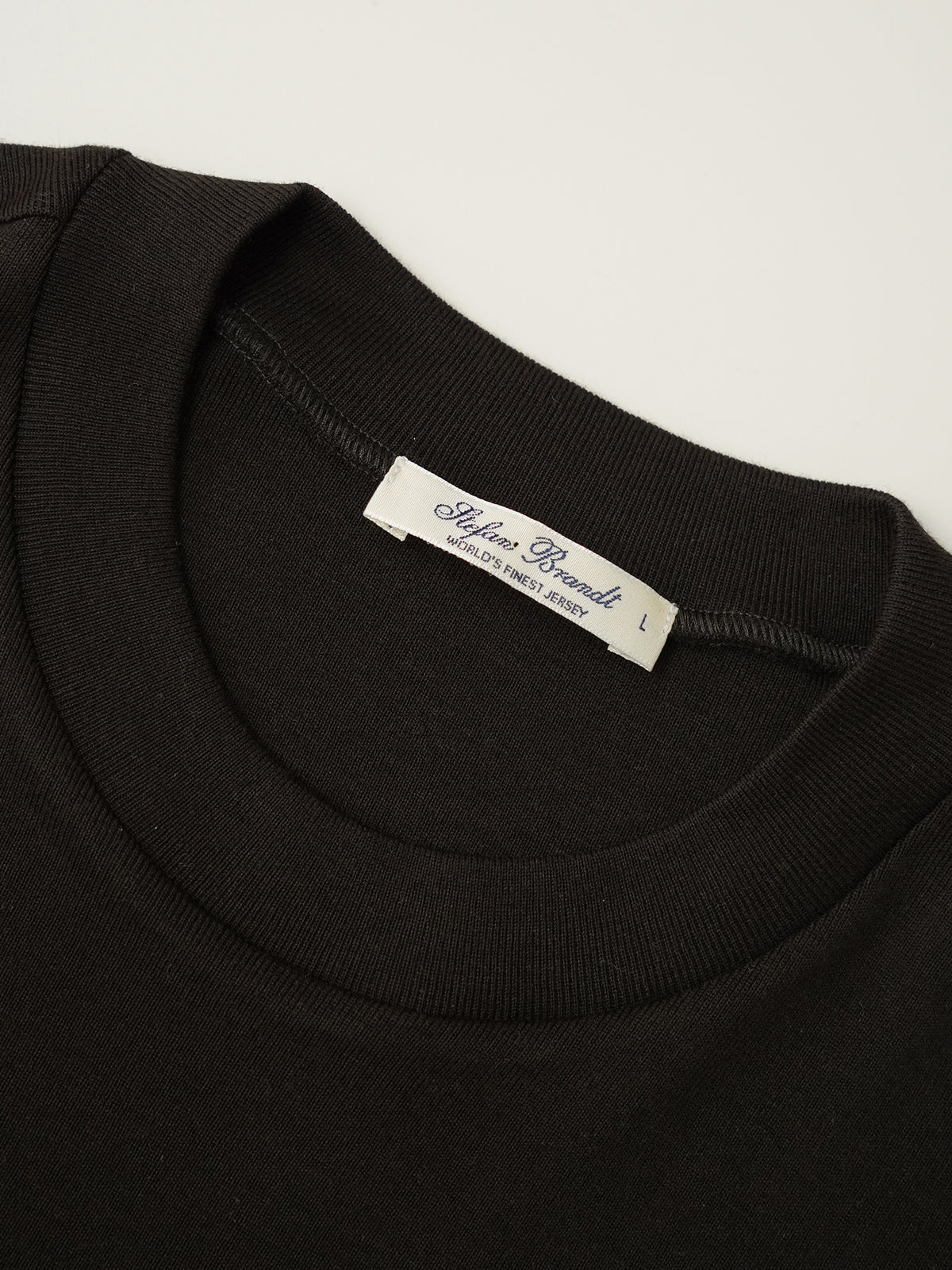 Dunkelbraunes T-Shirt aus feiner Rippe von Stefan Brandt – Detailansicht des Rundhalsausschnitts mit Label