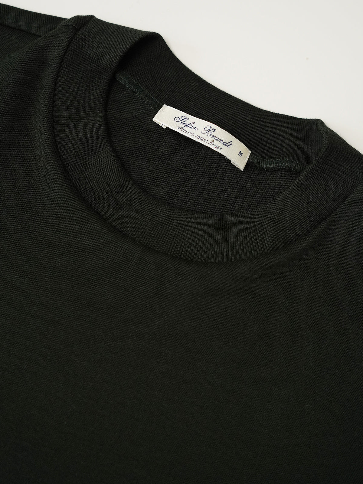 Flaschengrünes T-Shirt aus feiner Rippe von Stefan Brandt – Detailansicht des Rundhalsausschnitts mit Label
